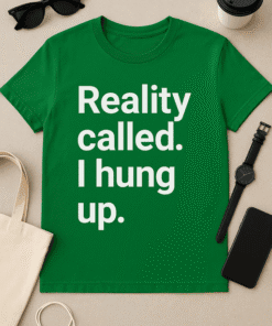 Black sunglasses and a coffee cup on a beige background, featuring a green T-shirt with humorous "Reality called. I hung up." slogan.