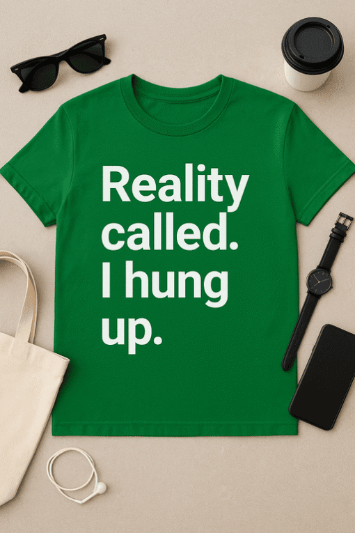 Black sunglasses and a coffee cup on a beige background, featuring a green T-shirt with humorous "Reality called. I hung up." slogan.