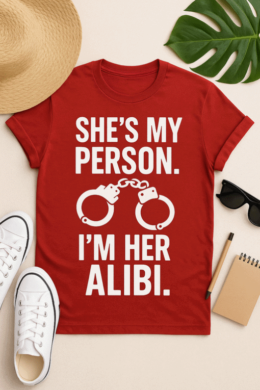 Handmade graphic t-shirt with humorous "she's my person, I'm her alibi" slogan and handcuff design, perfect for couples and gifts.