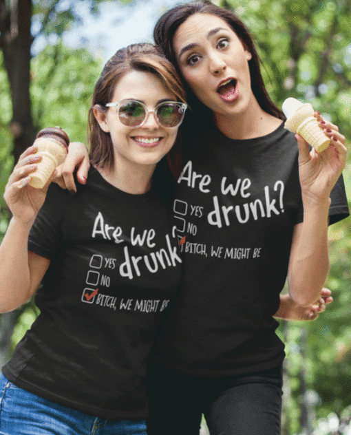 1. Two women wearing humorous "Are we drunk?" matching T-shirts holding ice cream cones outdoors.