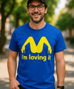 Happy person wearing a blue T-shirt with a fun, yellow graphic design and the phrase "I'm loving it" on a city street.