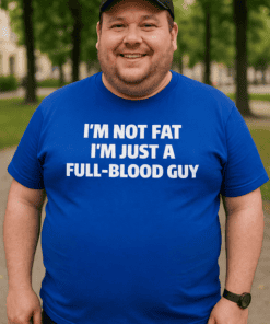 Bald man in a blue t-shirt with humorous text, outdoor park scene, casual fashion.