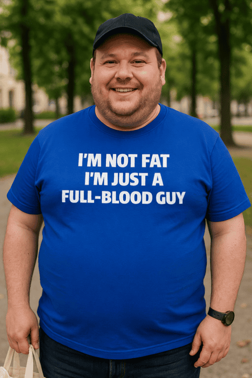 Bald man in a blue t-shirt with humorous text, outdoor park scene, casual fashion.