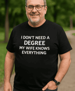 I don’t need a degree my wife knows everything, funny husband t-shirt, clever marriage humor tee, gift for husband, close up of man smiling in park.