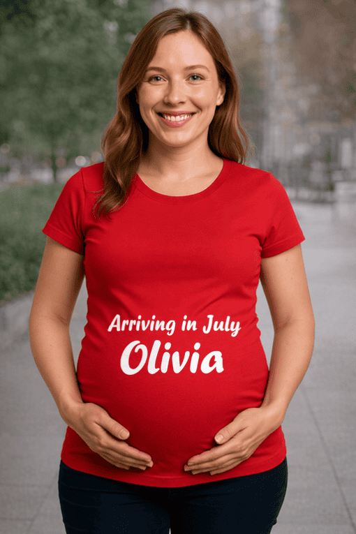 Pregnant woman wearing personalized pregnancy announcement T-shirt with name and arrival date, outdoor setting.
