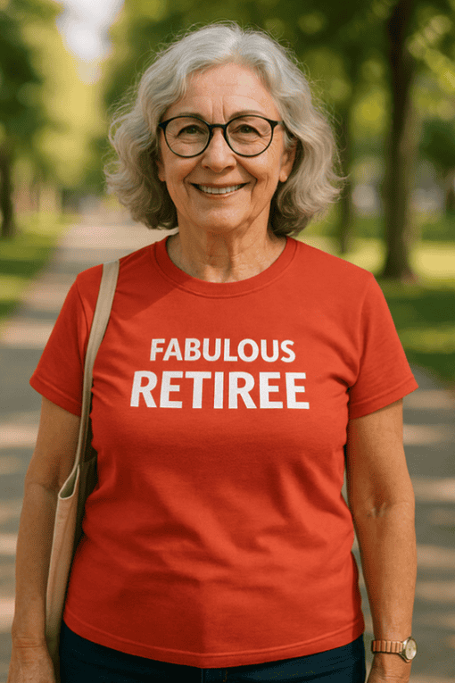 Elegant senior woman smiling outdoors wearing a red "Fabulous Retiree" T-shirt for retired life celebration.
