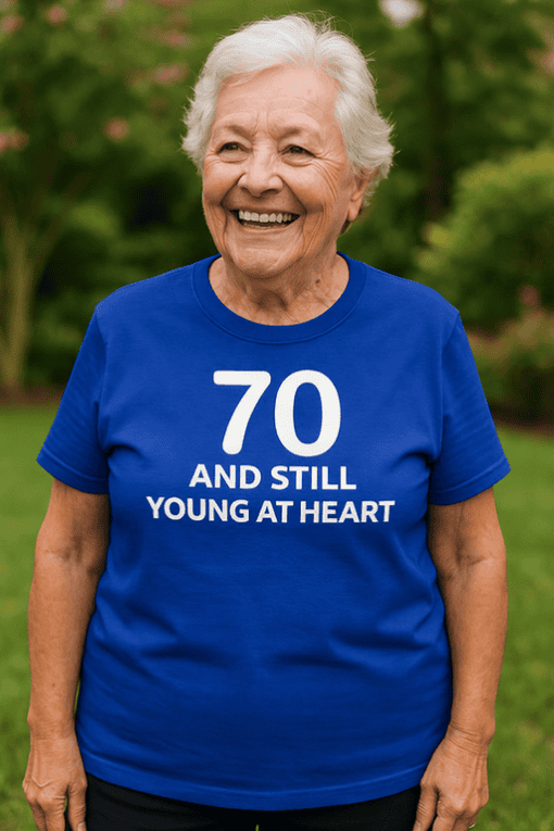 Happy senior woman wearing blue age 70 birthday T-shirt outdoor.