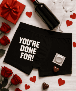 - Red wine bottle with glasses, roses, and Valentine's Day themed gifts on white wooden table.