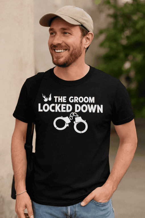 Handsome man wearing humorous wedding-themed T-shirt with handcuff graphic and playful message.