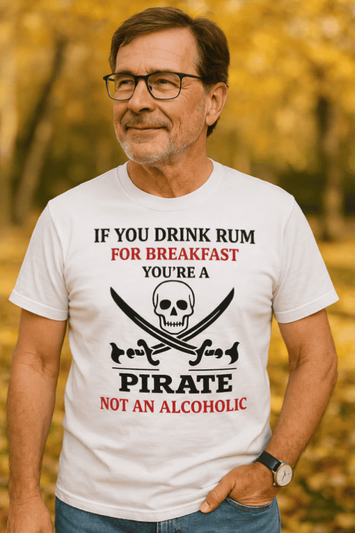 A man wearing a humorous pirate-themed T-shirt with skull and crossbones graphic, outdoors in fall.