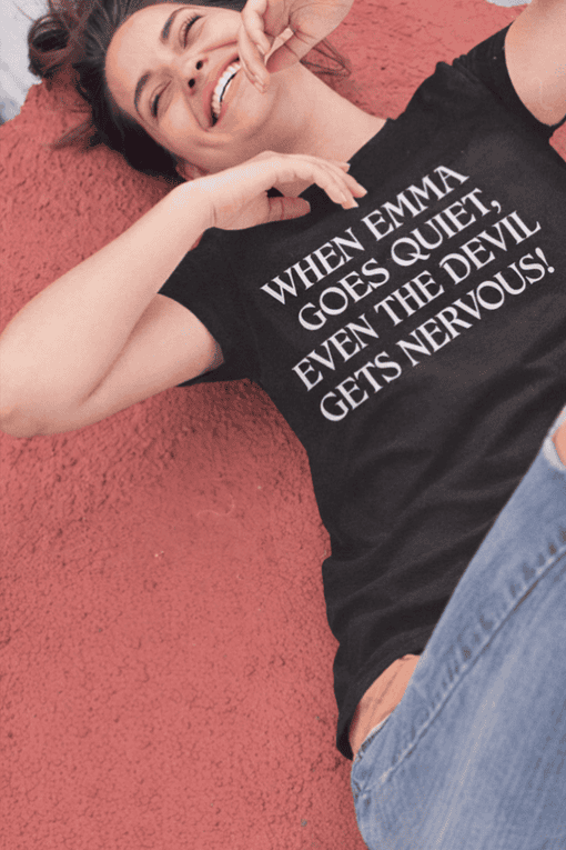 Happy woman lying on ground in black quote t-shirt about Emma and nervousness, casual fashion, relatable quote, trendy tee, comfortable clothing.