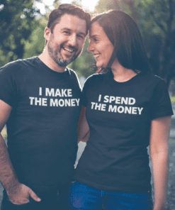 Laughing couple in black T-shirts, "I MAKE THE MONEY" and "I SPEND THE MONEY" standing outdoors, fun couple T-shirt design, matching couple shirts, humor tees.