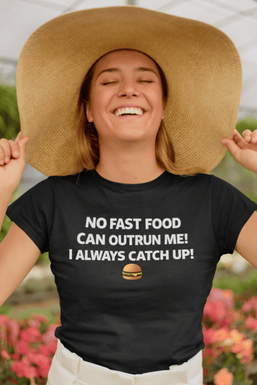 1. Women wearing black T-shirt with humorous fast food quote and oversized hat outdoors.