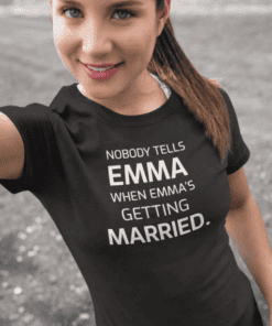 - Smiling woman in black T-shirt with humorous wedding quote, outdoors, casual style.