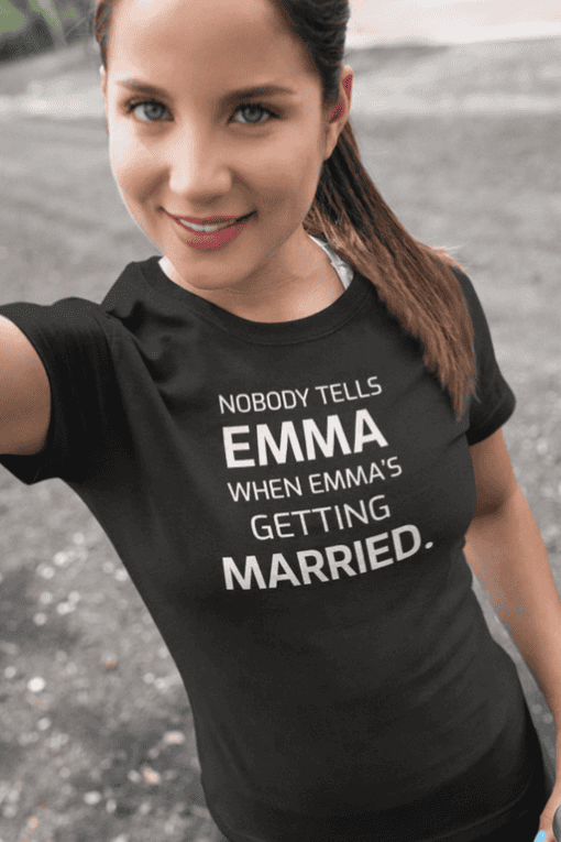 - Smiling woman in black T-shirt with humorous wedding quote, outdoors, casual style.