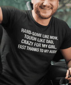 Handsome man in casual t-shirt with humorous text, smiling outdoors, promoting custom printed tees.