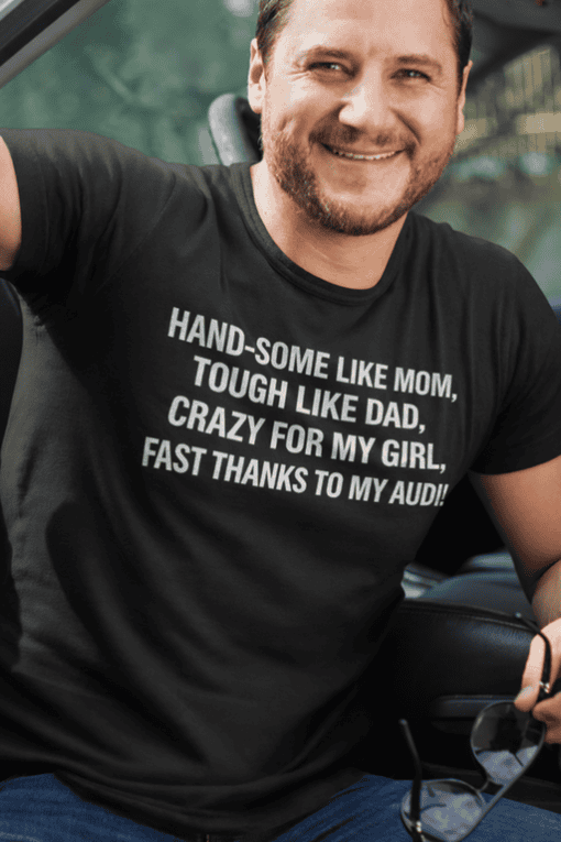 Handsome man in casual t-shirt with humorous text, smiling outdoors, promoting custom printed tees.