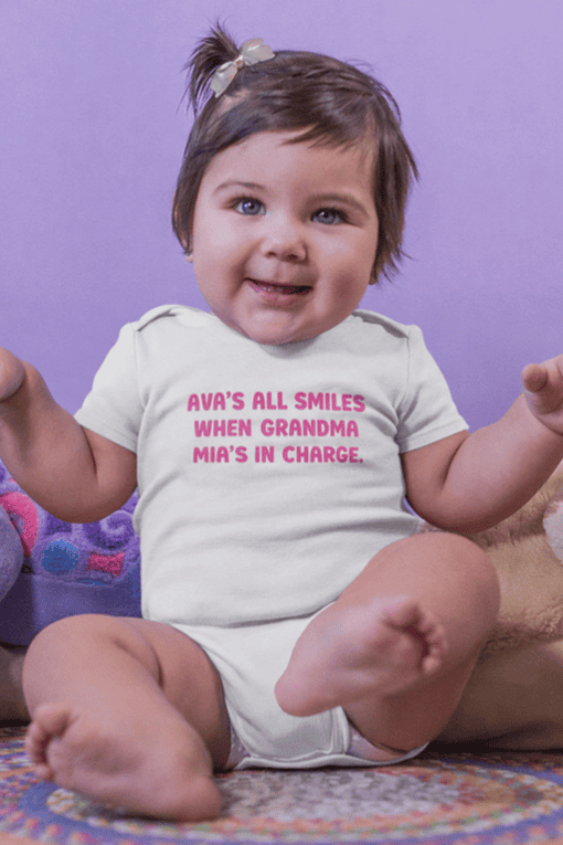 Cute baby girl with a happy expression wearing a personalized T-shirt from T-shirtplease.com.