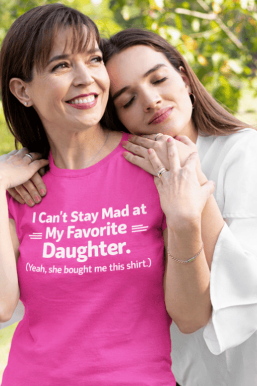 Mom and daughter embracing, wearing funny matching t-shirts, celebrating family bond.