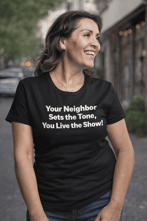 Cheerful woman wearing humorous T-shirt outdoors, casual fashion, street style, relatable humor, neighborhood vibe, lifestyle clothing, women’s casual wear.