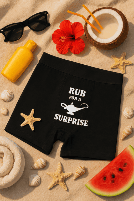 Sunglasses and summer accessories with humorous boxer shorts featuring "RUB FOR A SURPRISE" quote.